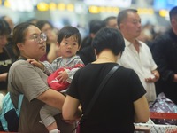 Passengers wait at the waiting hall of Hangzhou East Railway Station in Hangzhou, China, on September 30, 2024. On the day before the Nation...