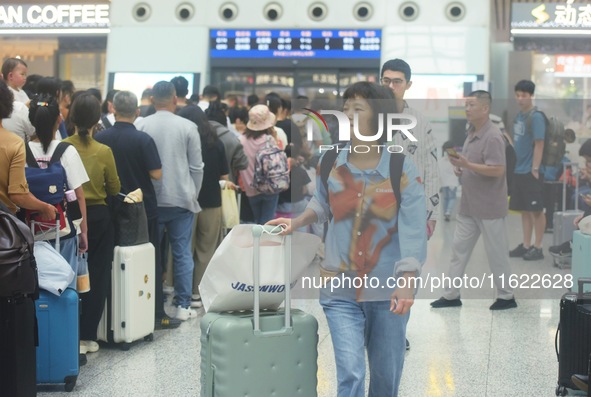 Passengers wait at the waiting hall of Hangzhou East Railway Station in Hangzhou, China, on September 30, 2024. On the day before the Nation...