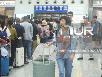 Passengers wait at the waiting hall of Hangzhou East Railway Station in Hangzhou, China, on September 30, 2024. On the day before the Nation...