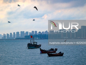 Fishing boats return to the coast of Gujia Island, a new area on the west coast of Qingdao, Shandong province, China, on September 29, 2024....