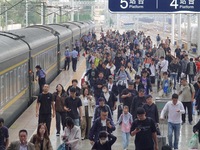 Passengers get off the train at Yantai Station in Yantai, China, on September 30, 2024. According to the China National Railway Group Co., L...