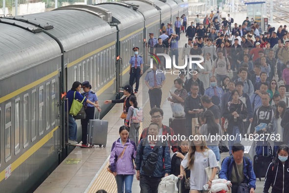 Passengers get off the train at Yantai Station in Yantai, China, on September 30, 2024. According to the China National Railway Group Co., L...