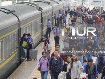 Passengers get off the train at Yantai Station in Yantai, China, on September 30, 2024. According to the China National Railway Group Co., L...