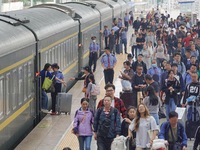 Passengers get off the train at Yantai Station in Yantai, China, on September 30, 2024. According to the China National Railway Group Co., L...