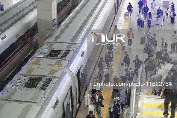 Passengers take a train at Yantai Station in Yantai, China, on September 30, 2024. According to the China National Railway Group Co., LTD.,...