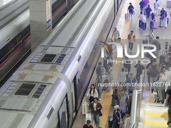 Passengers take a train at Yantai Station in Yantai, China, on September 30, 2024. According to the China National Railway Group Co., LTD.,...