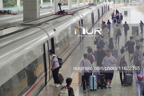 Passengers take a train at Yantai Station in Yantai, China, on September 30, 2024. According to the China National Railway Group Co., LTD.,...