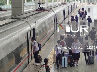 Passengers take a train at Yantai Station in Yantai, China, on September 30, 2024. According to the China National Railway Group Co., LTD.,...