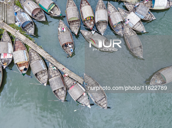 An aerial view shows boatmen navigating their vessel across the Shitalakshya River, carrying passengers from Bandar Ghat in Narayanganj, Ban...