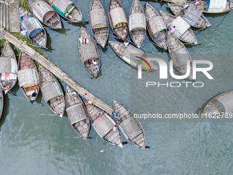 An aerial view shows boatmen navigating their vessel across the Shitalakshya River, carrying passengers from Bandar Ghat in Narayanganj, Ban...