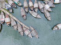 An aerial view shows boatmen navigating their vessel across the Shitalakshya River, carrying passengers from Bandar Ghat in Narayanganj, Ban...