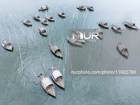 An aerial view shows boatmen navigating their vessel across the Shitalakshya River, carrying passengers from Bandar Ghat in Narayanganj, Ban...