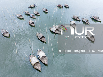 An aerial view shows boatmen navigating their vessel across the Shitalakshya River, carrying passengers from Bandar Ghat in Narayanganj, Ban...