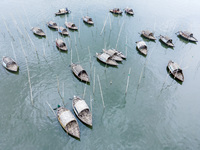 An aerial view shows boatmen navigating their vessel across the Shitalakshya River, carrying passengers from Bandar Ghat in Narayanganj, Ban...