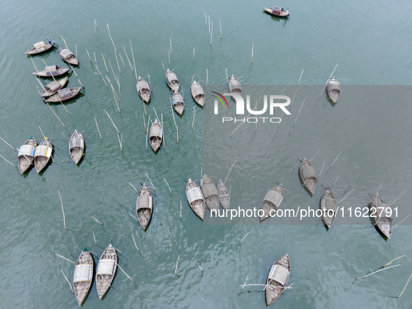 An aerial view shows boatmen navigating their vessel across the Shitalakshya River, carrying passengers from Bandar Ghat in Narayanganj, Ban...