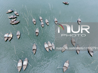 An aerial view shows boatmen navigating their vessel across the Shitalakshya River, carrying passengers from Bandar Ghat in Narayanganj, Ban...