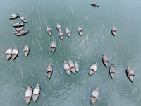 An aerial view shows boatmen navigating their vessel across the Shitalakshya River, carrying passengers from Bandar Ghat in Narayanganj, Ban...