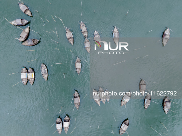 An aerial view shows boatmen navigating their vessel across the Shitalakshya River, carrying passengers from Bandar Ghat in Narayanganj, Ban...