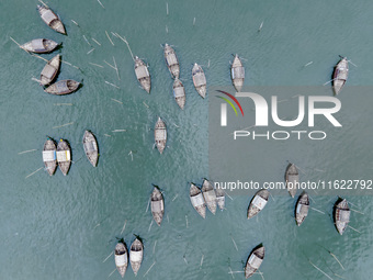 An aerial view shows boatmen navigating their vessel across the Shitalakshya River, carrying passengers from Bandar Ghat in Narayanganj, Ban...