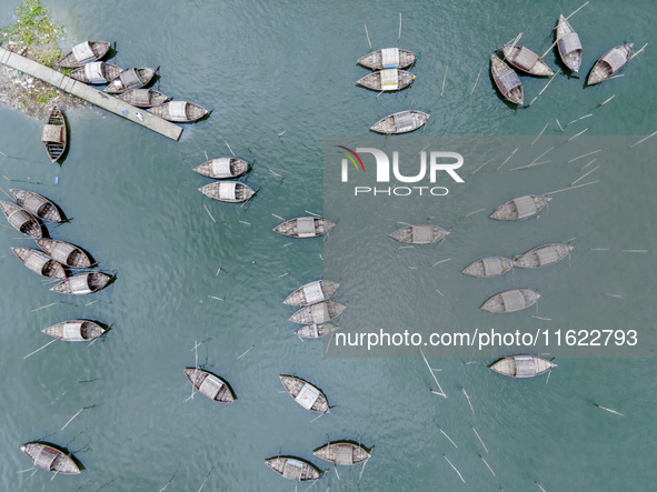 An aerial view shows boatmen navigating their vessel across the Shitalakshya River, carrying passengers from Bandar Ghat in Narayanganj, Ban...