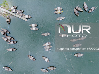 An aerial view shows boatmen navigating their vessel across the Shitalakshya River, carrying passengers from Bandar Ghat in Narayanganj, Ban...