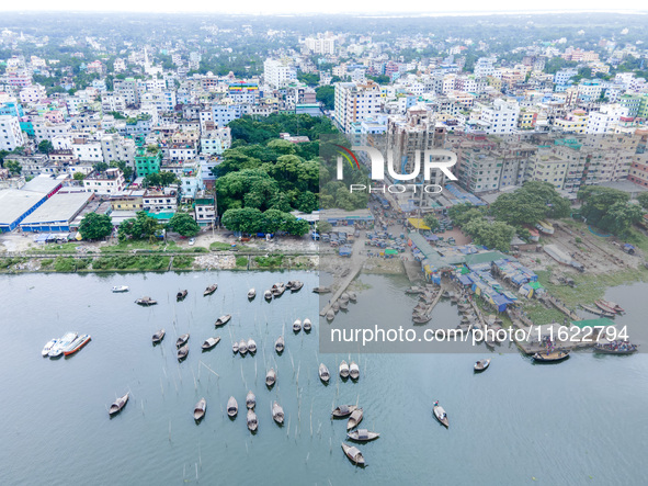 An aerial view shows boatmen navigating their vessel across the Shitalakshya River, carrying passengers from Bandar Ghat in Narayanganj, Ban...