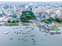 An aerial view shows boatmen navigating their vessel across the Shitalakshya River, carrying passengers from Bandar Ghat in Narayanganj, Ban...