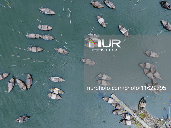 An aerial view shows boatmen navigating their vessel across the Shitalakshya River, carrying passengers from Bandar Ghat in Narayanganj, Ban...