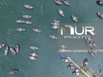 An aerial view shows boatmen navigating their vessel across the Shitalakshya River, carrying passengers from Bandar Ghat in Narayanganj, Ban...