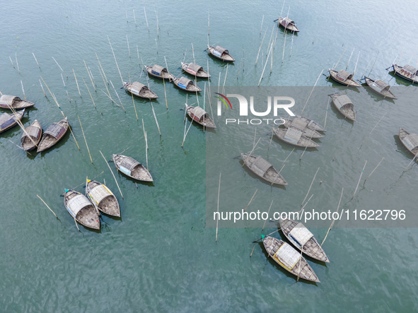 An aerial view shows boatmen navigating their vessel across the Shitalakshya River, carrying passengers from Bandar Ghat in Narayanganj, Ban...