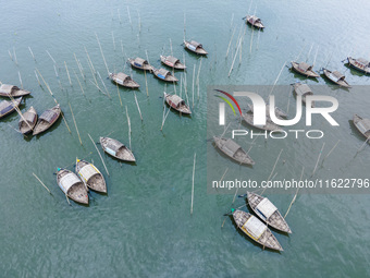 An aerial view shows boatmen navigating their vessel across the Shitalakshya River, carrying passengers from Bandar Ghat in Narayanganj, Ban...