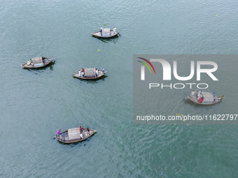 An aerial view shows boatmen navigating their vessel across the Shitalakshya River, carrying passengers from Bandar Ghat in Narayanganj, Ban...