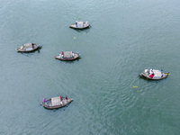 An aerial view shows boatmen navigating their vessel across the Shitalakshya River, carrying passengers from Bandar Ghat in Narayanganj, Ban...