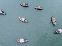 An aerial view shows boatmen navigating their vessel across the Shitalakshya River, carrying passengers from Bandar Ghat in Narayanganj, Ban...