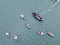 An aerial view shows boatmen navigating their vessel across the Shitalakshya River, carrying passengers from Bandar Ghat in Narayanganj, Ban...