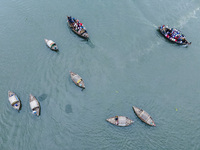 An aerial view shows boatmen navigating their vessel across the Shitalakshya River, carrying passengers from Bandar Ghat in Narayanganj, Ban...