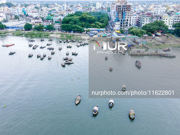 An aerial view shows boatmen navigating their vessel across the Shitalakshya River, carrying passengers from Bandar Ghat in Narayanganj, Ban...