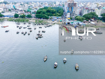 An aerial view shows boatmen navigating their vessel across the Shitalakshya River, carrying passengers from Bandar Ghat in Narayanganj, Ban...