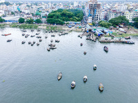 An aerial view shows boatmen navigating their vessel across the Shitalakshya River, carrying passengers from Bandar Ghat in Narayanganj, Ban...