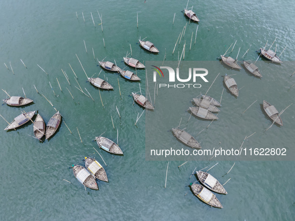 An aerial view shows boatmen navigating their vessel across the Shitalakshya River, carrying passengers from Bandar Ghat in Narayanganj, Ban...