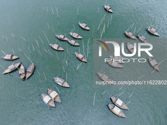 An aerial view shows boatmen navigating their vessel across the Shitalakshya River, carrying passengers from Bandar Ghat in Narayanganj, Ban...