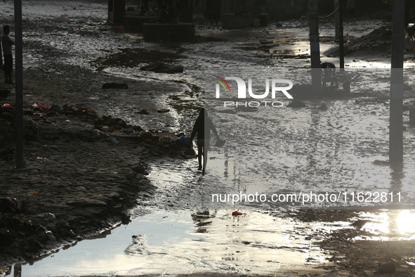 A man walks along the embankments of the Bagmati River along the trails of dumped plastics after flooding in Kathmandu, Nepal, on September...