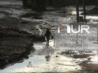 A man walks along the embankments of the Bagmati River along the trails of dumped plastics after flooding in Kathmandu, Nepal, on September...