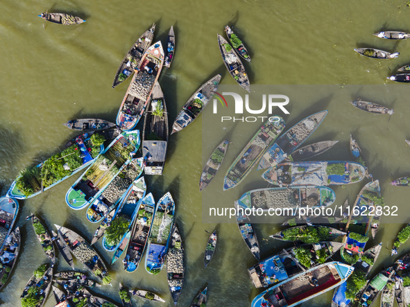 An aerial view shows traders selling fruits and vegetables from boats at Boithakata floating market on the Belua River in Pirojpur, Barisal,...