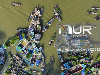 An aerial view shows traders selling fruits and vegetables from boats at Boithakata floating market on the Belua River in Pirojpur, Barisal,...