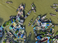 An aerial view shows traders selling fruits and vegetables from boats at Boithakata floating market on the Belua River in Pirojpur, Barisal,...