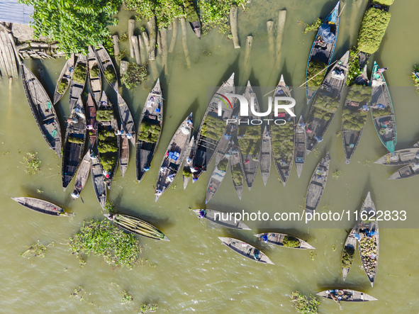 An aerial view shows traders selling fruits and vegetables from boats at Boithakata floating market on the Belua River in Pirojpur, Barisal,...