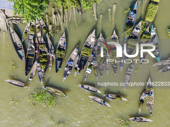 An aerial view shows traders selling fruits and vegetables from boats at Boithakata floating market on the Belua River in Pirojpur, Barisal,...