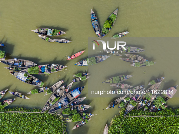 An aerial view shows traders selling fruits and vegetables from boats at Boithakata floating market on the Belua River in Pirojpur, Barisal,...