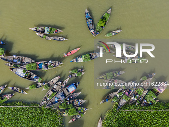 An aerial view shows traders selling fruits and vegetables from boats at Boithakata floating market on the Belua River in Pirojpur, Barisal,...